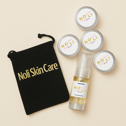 A collection of travel-size skin care products from Noli Skin Care, including four skin butter minis and a Body Elixir sample, displayed on a neutral background with a black drawstring bag labeled 'Noli Skin Care'.